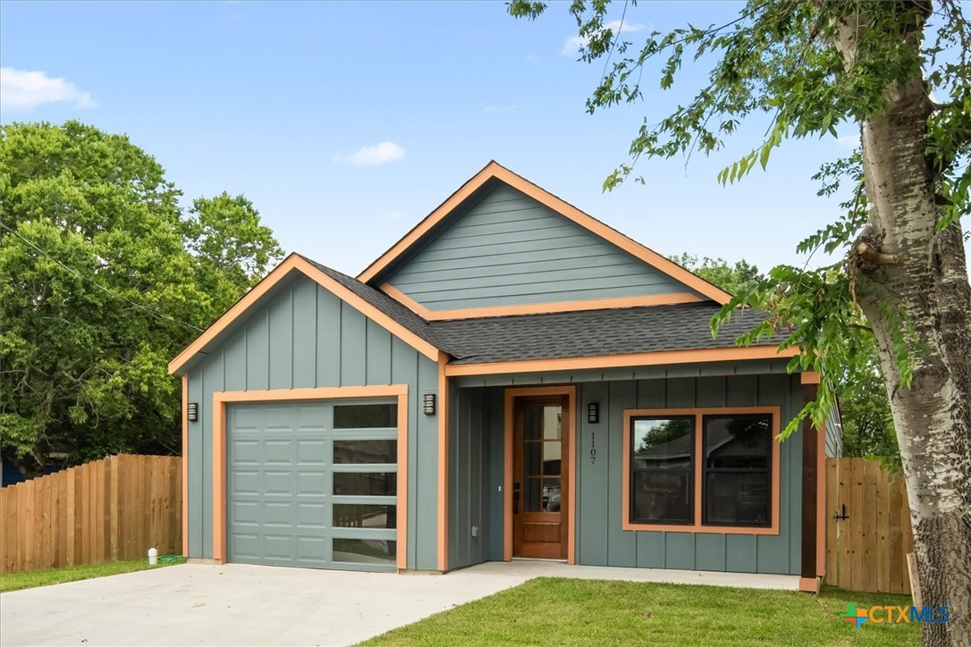 a view of a house with a yard and garage