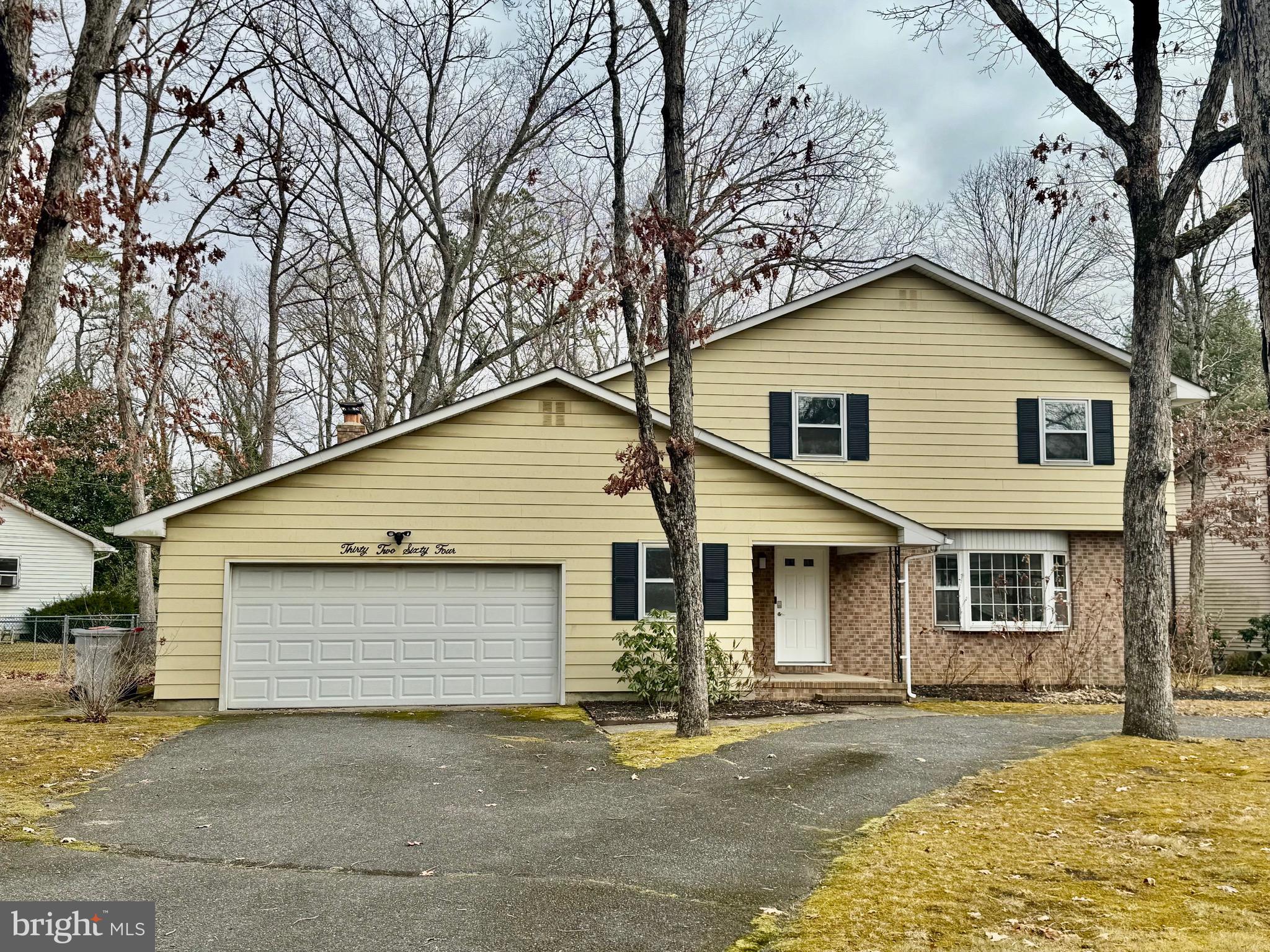 a front view of a house with a garage and yard