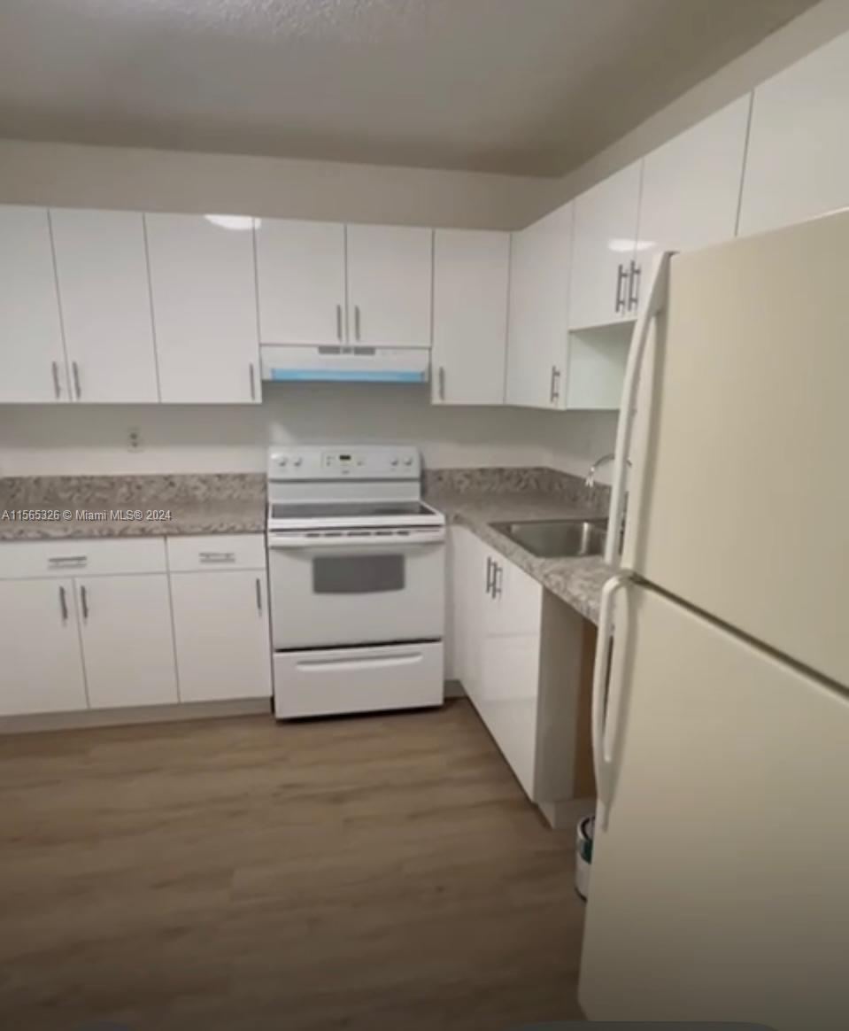 a kitchen with white cabinets and white stainless steel appliances