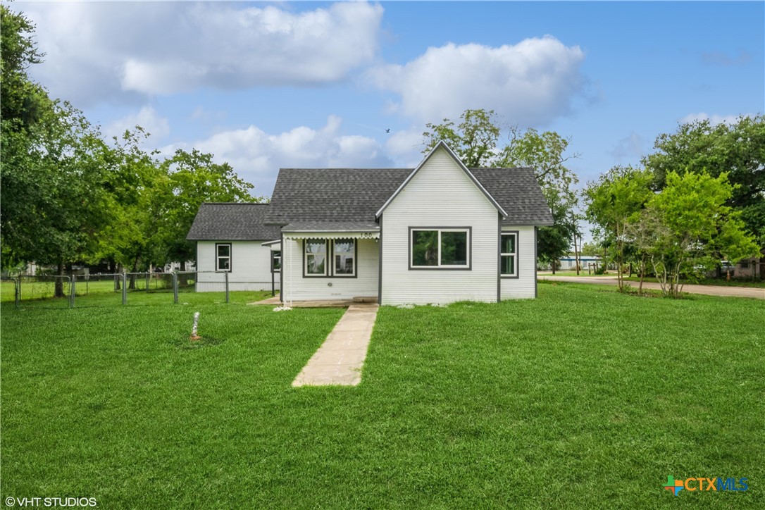 a front view of a house with a yard and trees