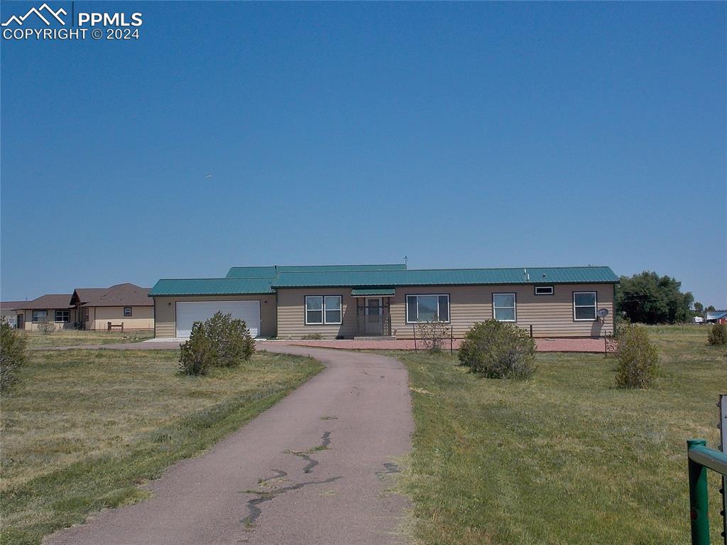 View of front of house with a garage and a front lawn