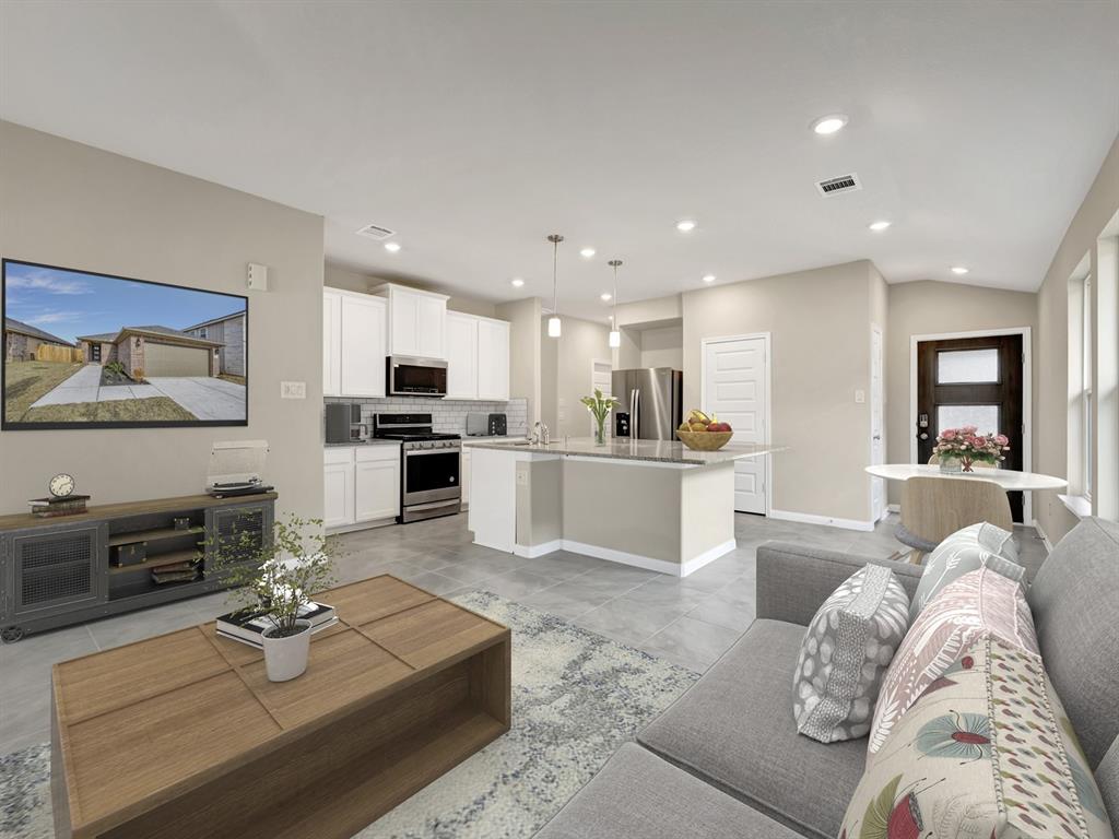 a living room with furniture kitchen view and a wooden floor