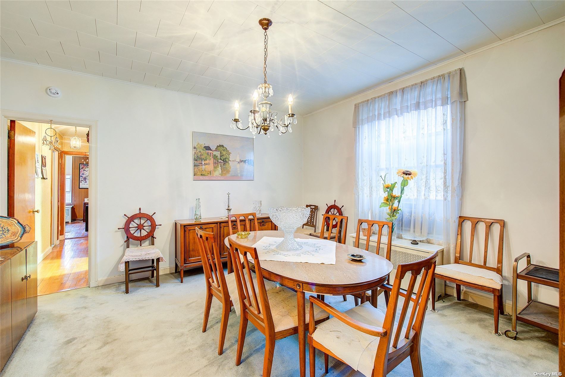 a dining room with furniture a chandelier and window