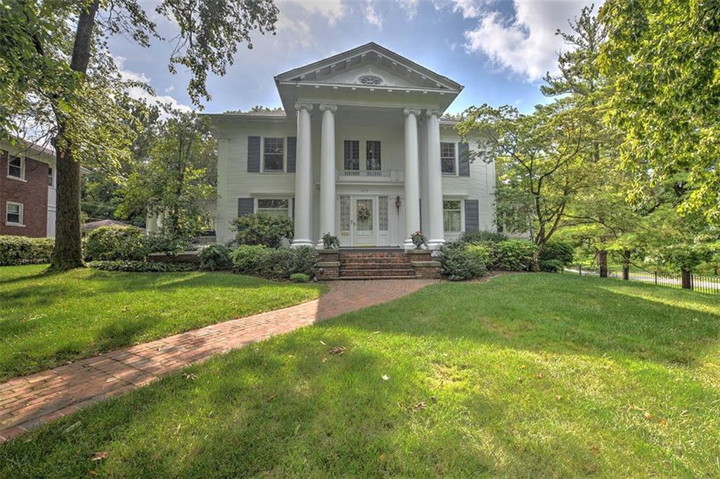 a front view of a house with a yard and trees