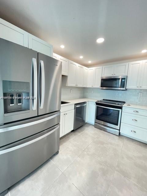 a kitchen with stainless steel appliances a stove microwave and a refrigerator