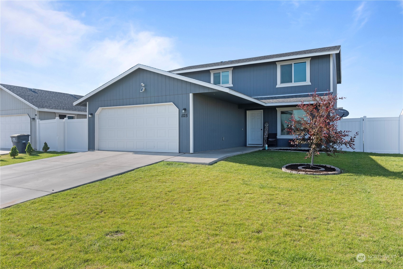 a front view of a house with yard and garage