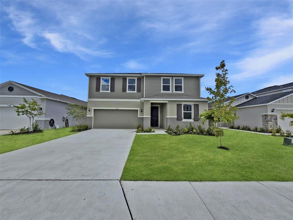 a front view of a house with a yard and garage