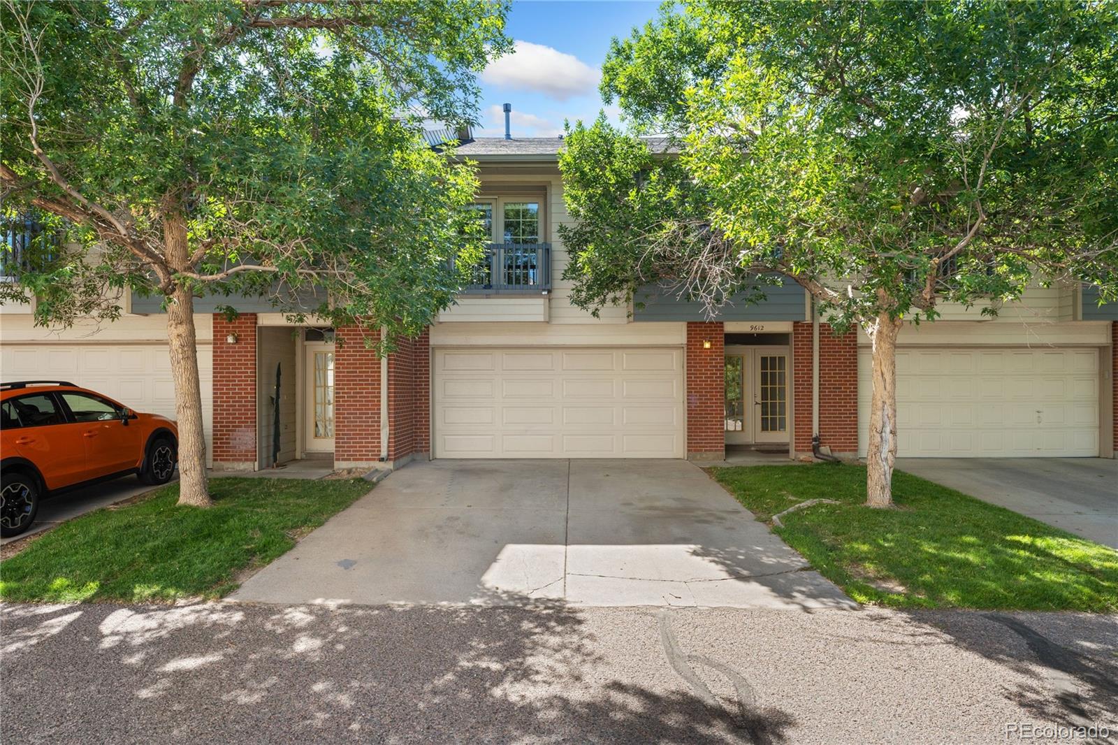 a front view of a house with a yard and a garage