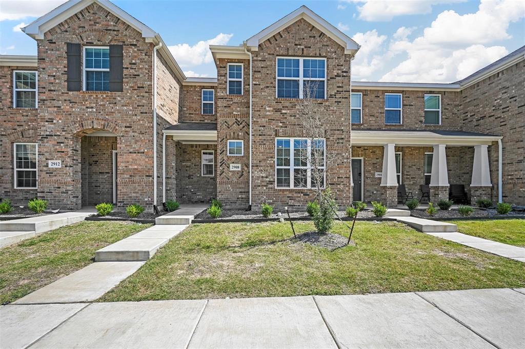 front view of a brick house next to a yard