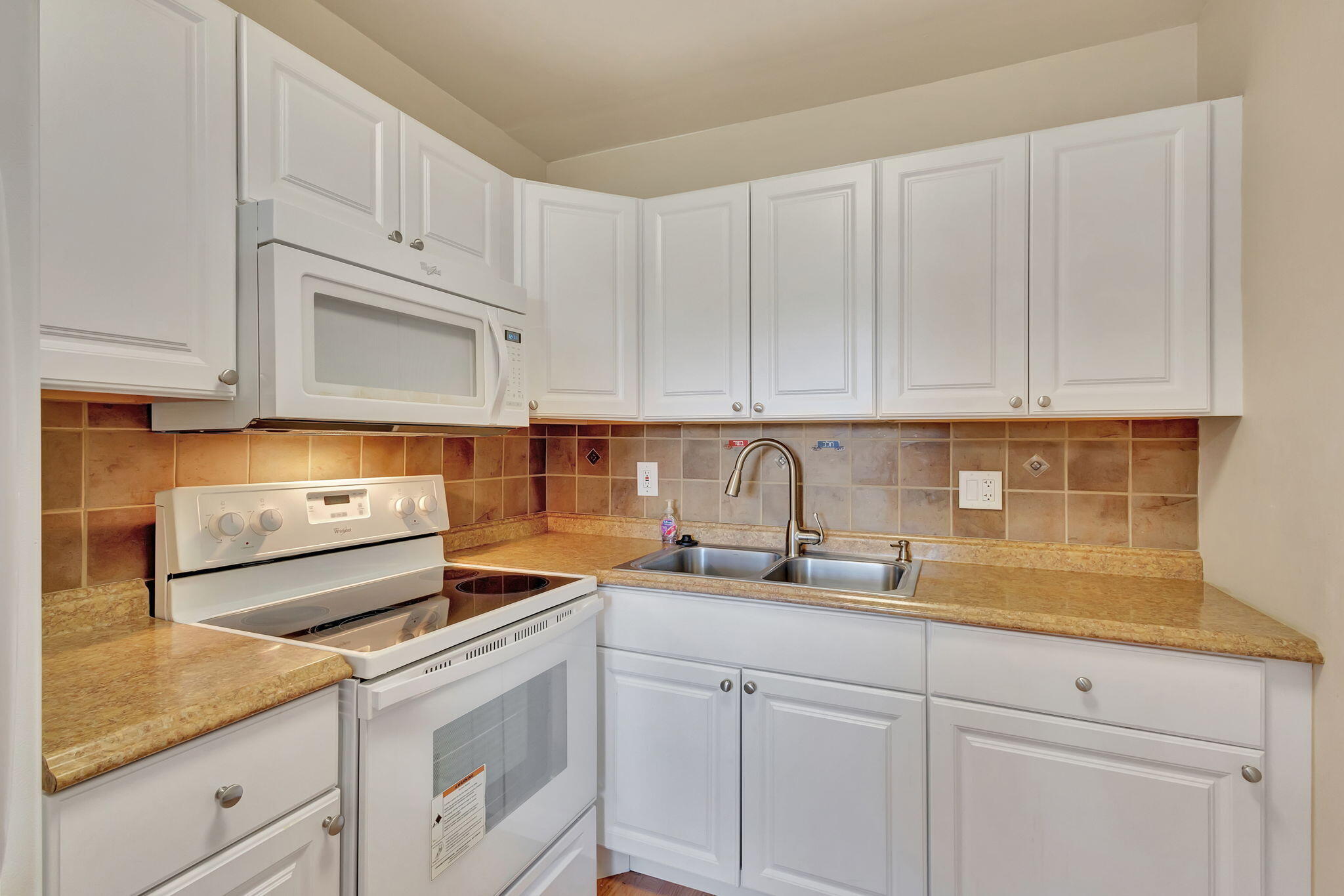 a kitchen with white cabinets and white appliances