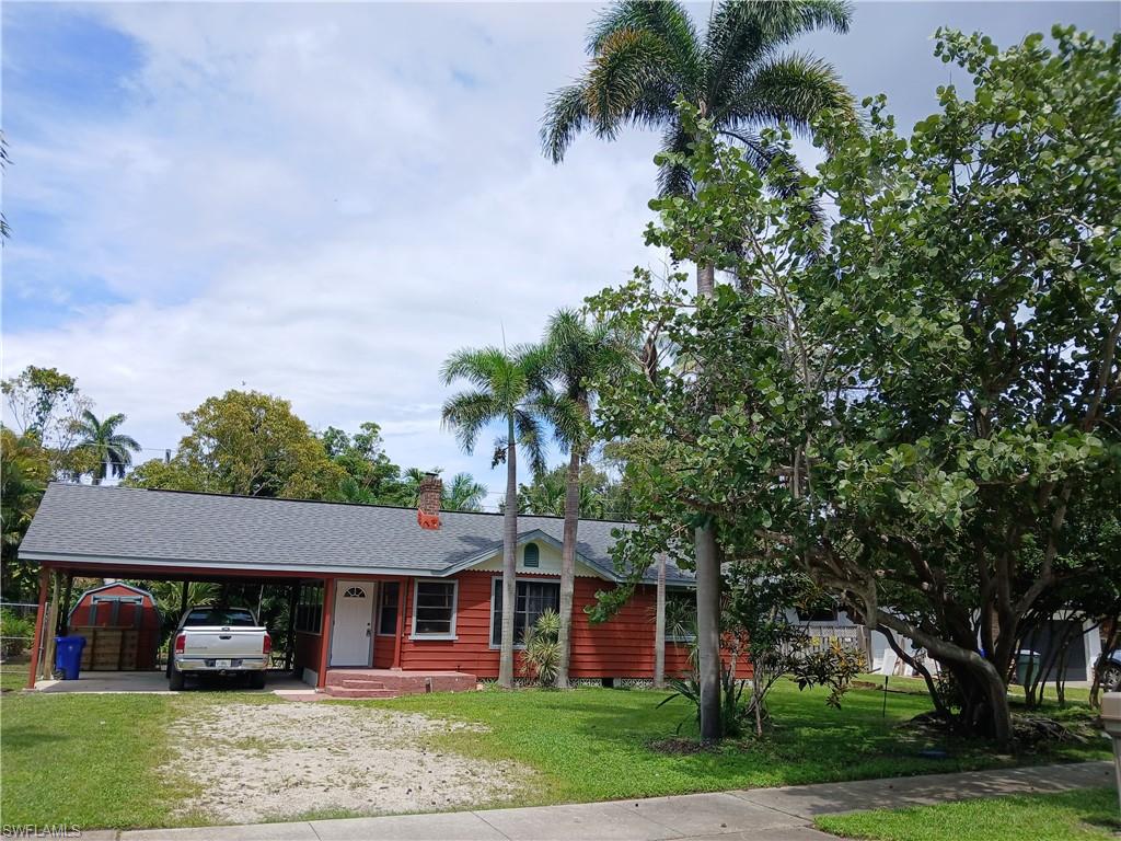 Ranch-style home featuring new roof 3/2024, a front yard with mature trees and a double attached carport