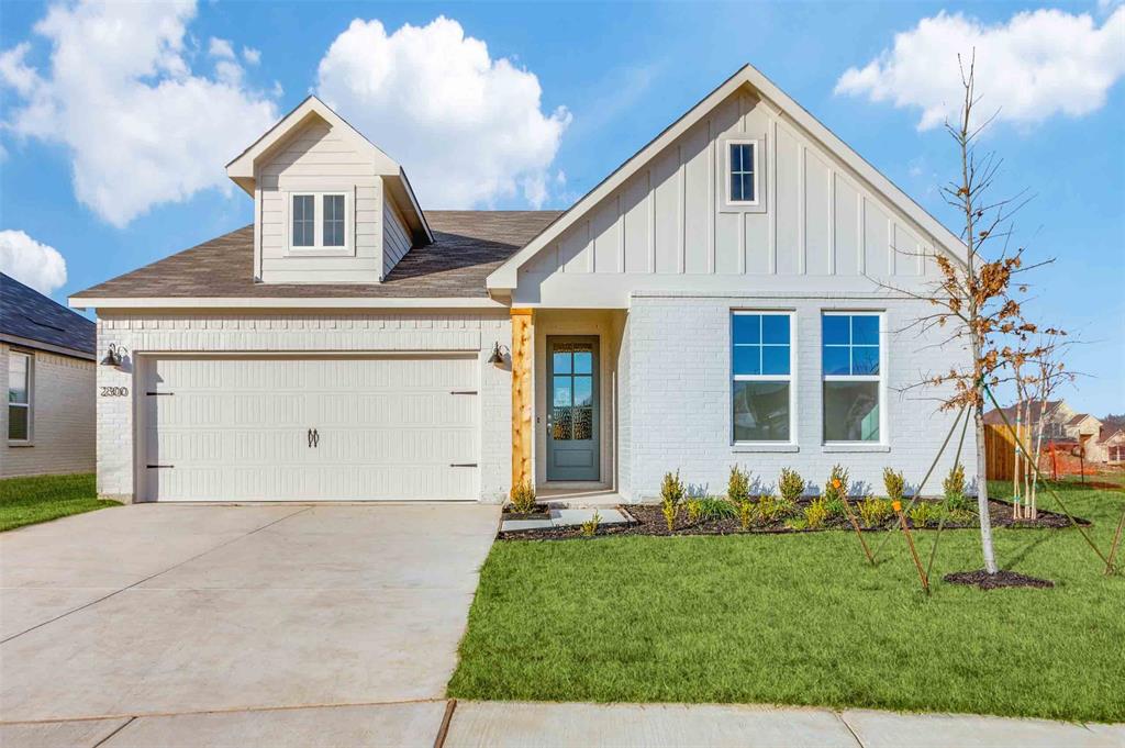 View of front of property with a garage and a front yard