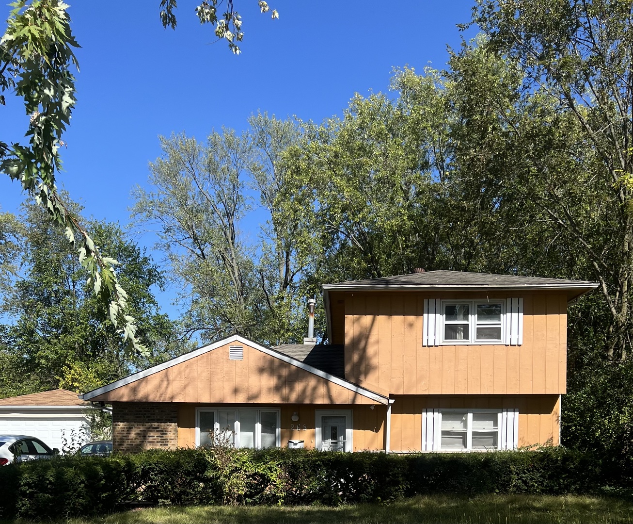 aerial view of house with yard and trees in the background