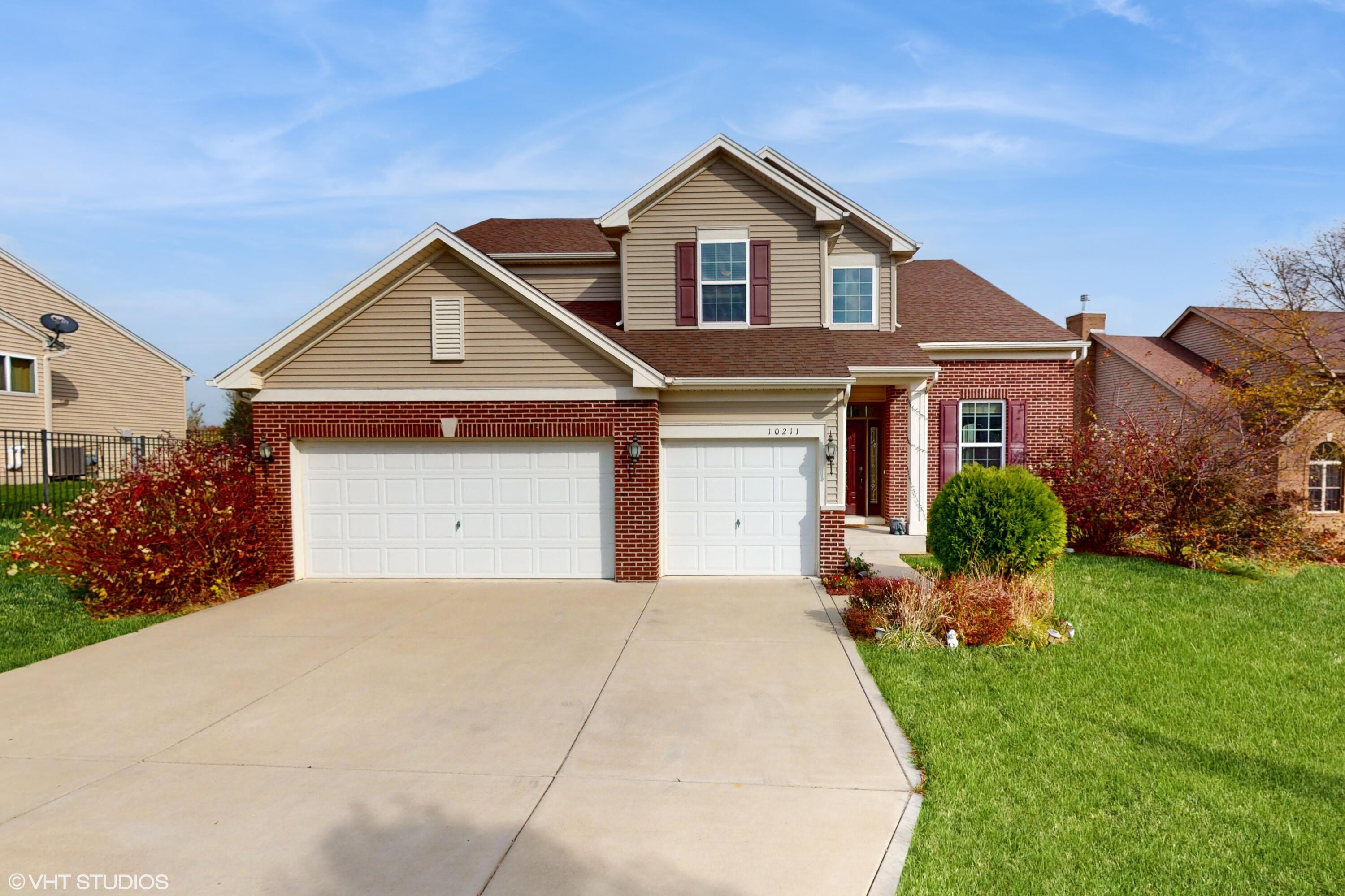 a front view of a house with a yard and garage