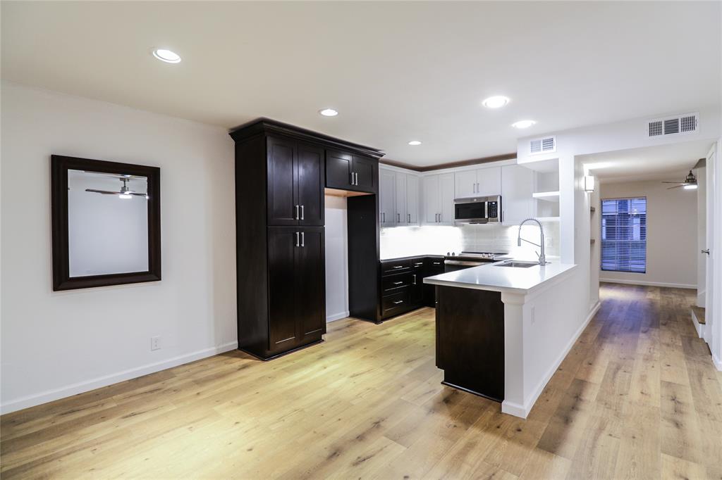 a large kitchen with a stove a refrigerator and a sink