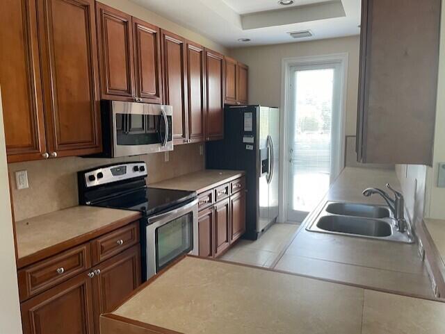 a kitchen with stainless steel appliances granite countertop a sink stove refrigerator and cabinets