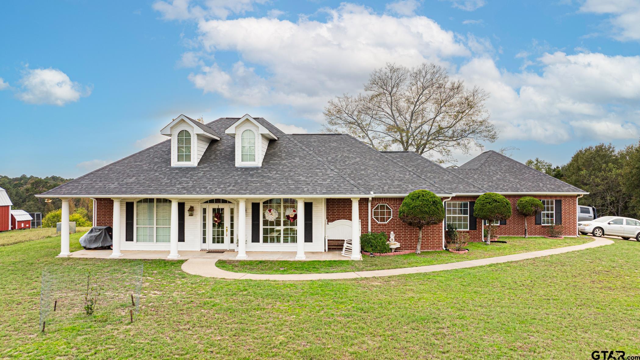 a view of a house with a swimming pool and a yard