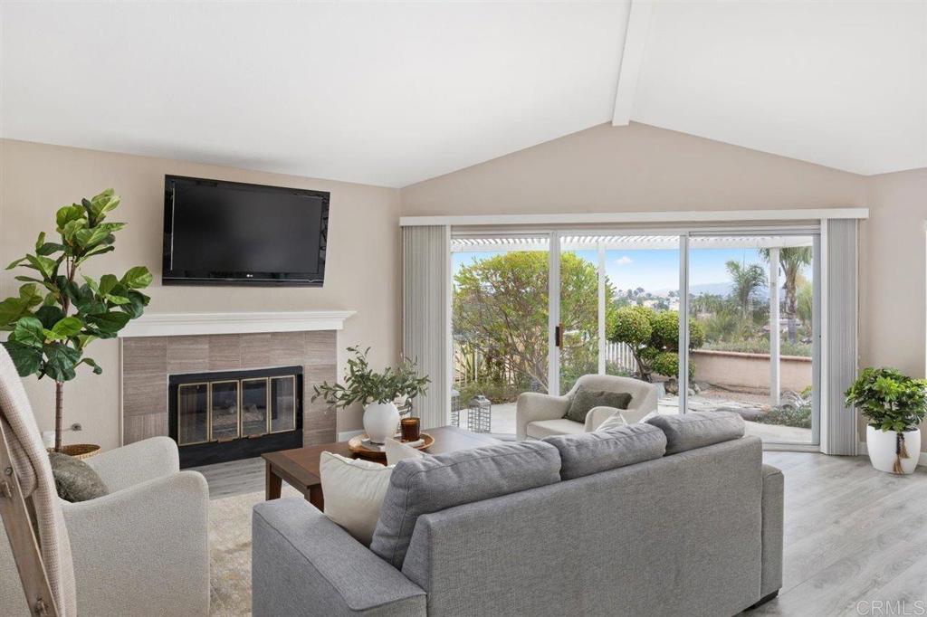 a living room with furniture a fireplace and a flat screen tv