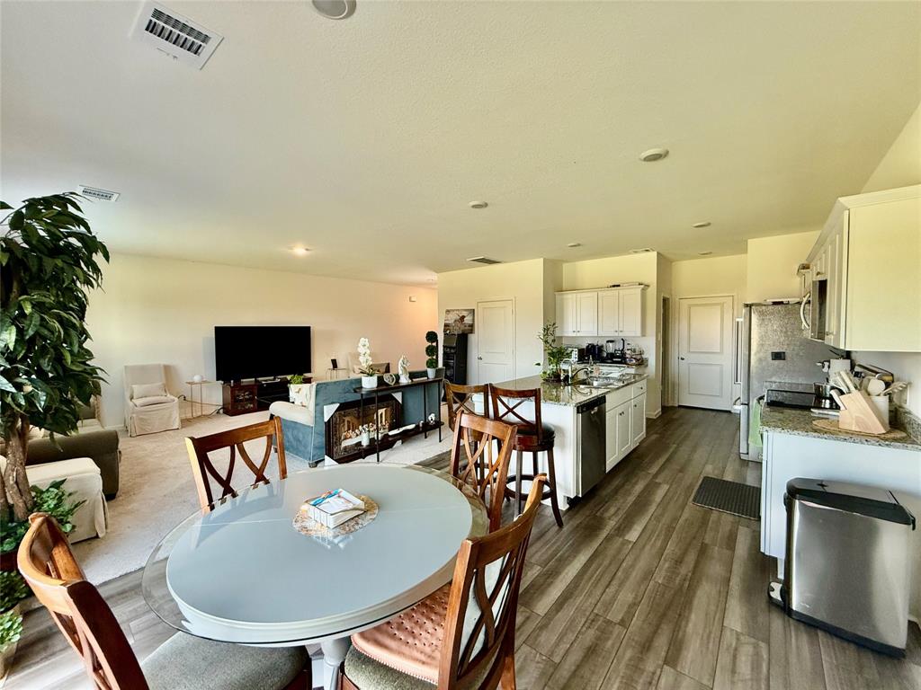 a kitchen with sink refrigerator dining table and chairs