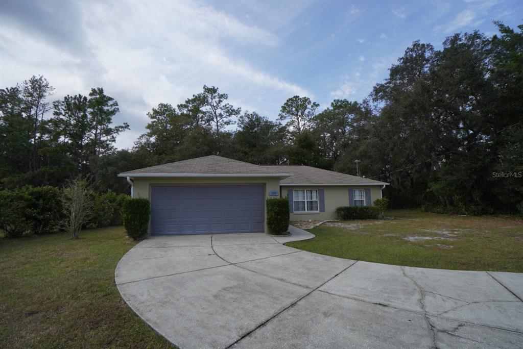 a front view of a house with a yard and trees