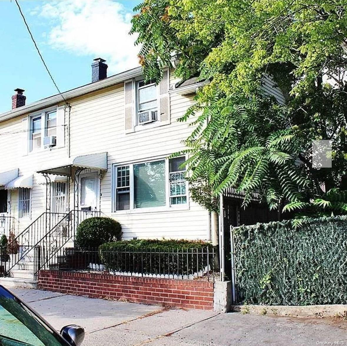 a front view of a house with garage and plants