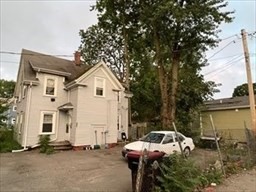 a view of a white house with a sink and backyard