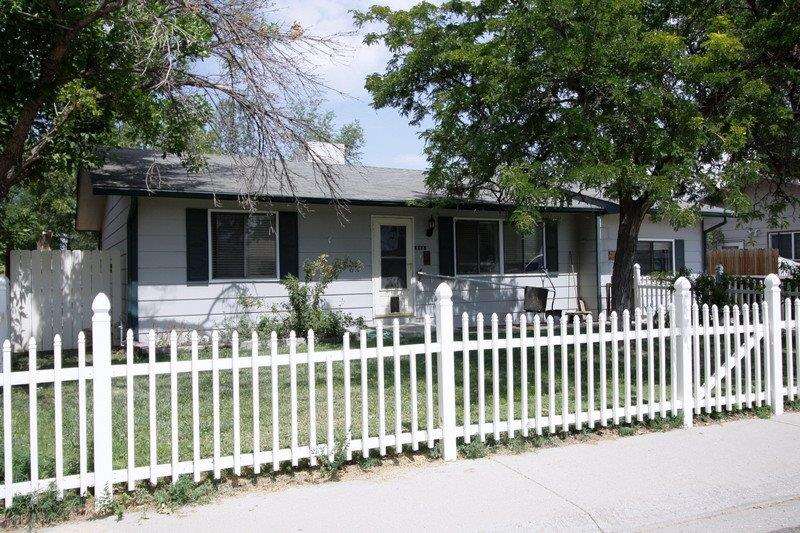 a front view of white house with a small yard