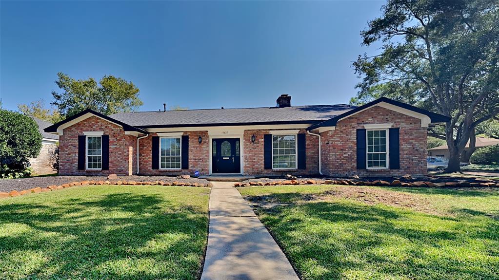 a front view of a house with a yard and trees