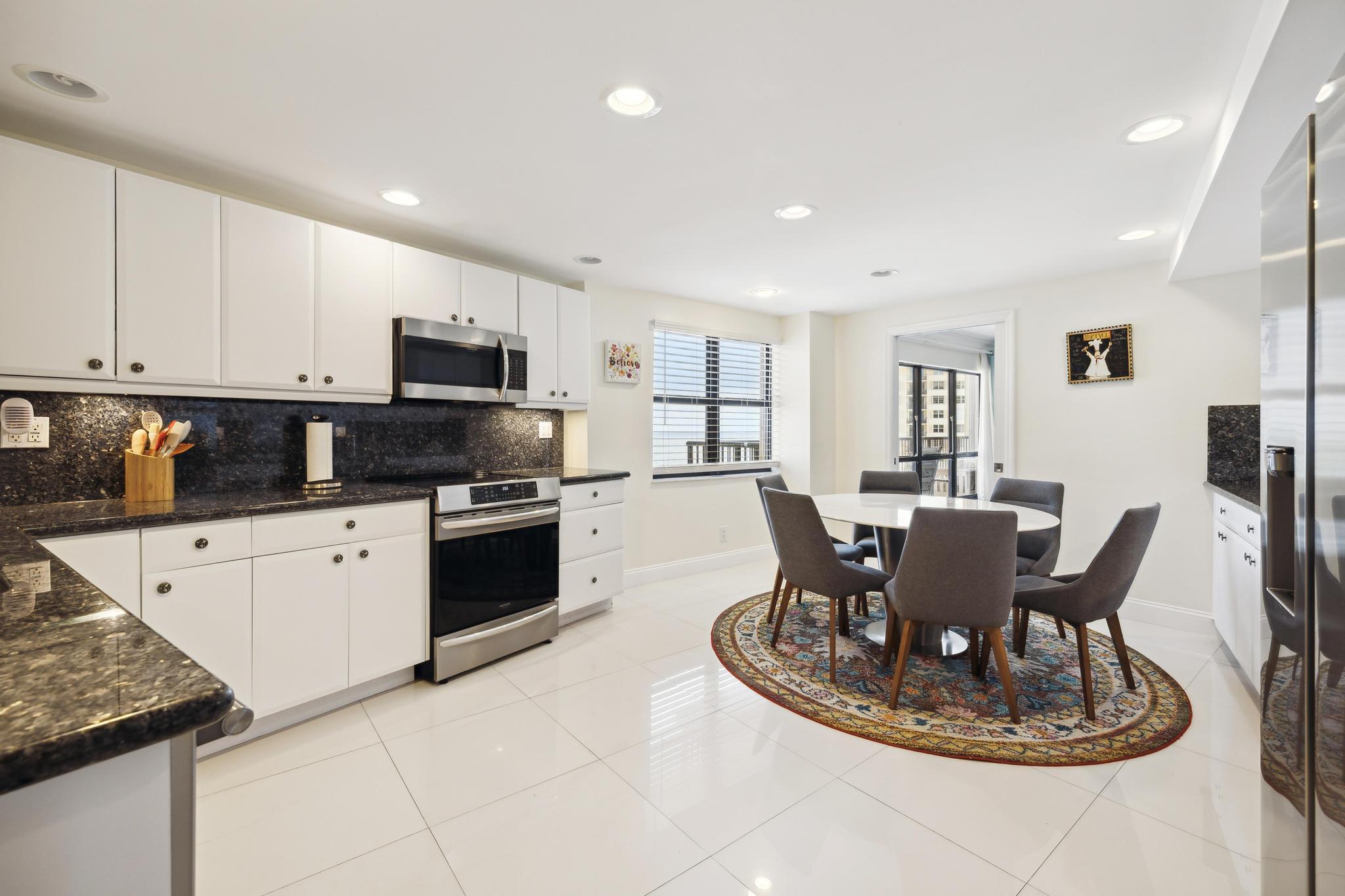 a kitchen with a dining table chairs and refrigerator