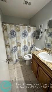 a bathroom with a granite countertop sink a toilet and shower