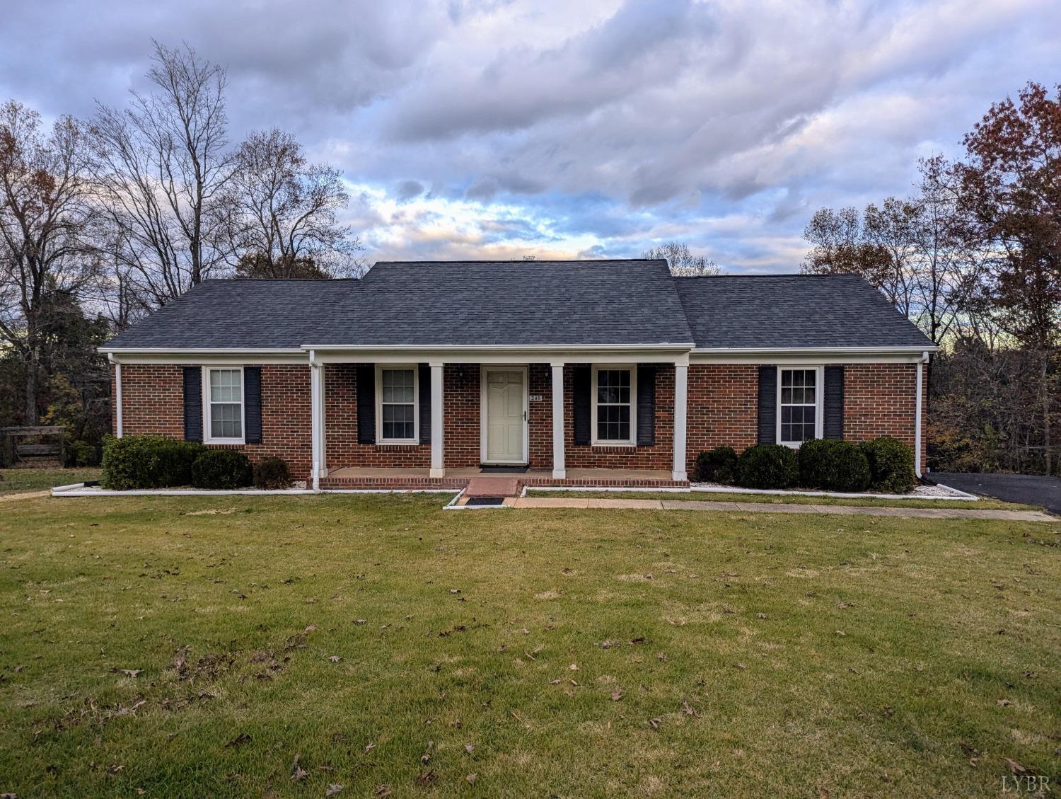 front view of a brick house with a yard