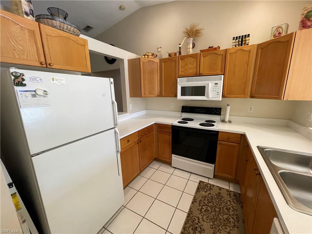 a kitchen with a refrigerator a stove top oven and a sink