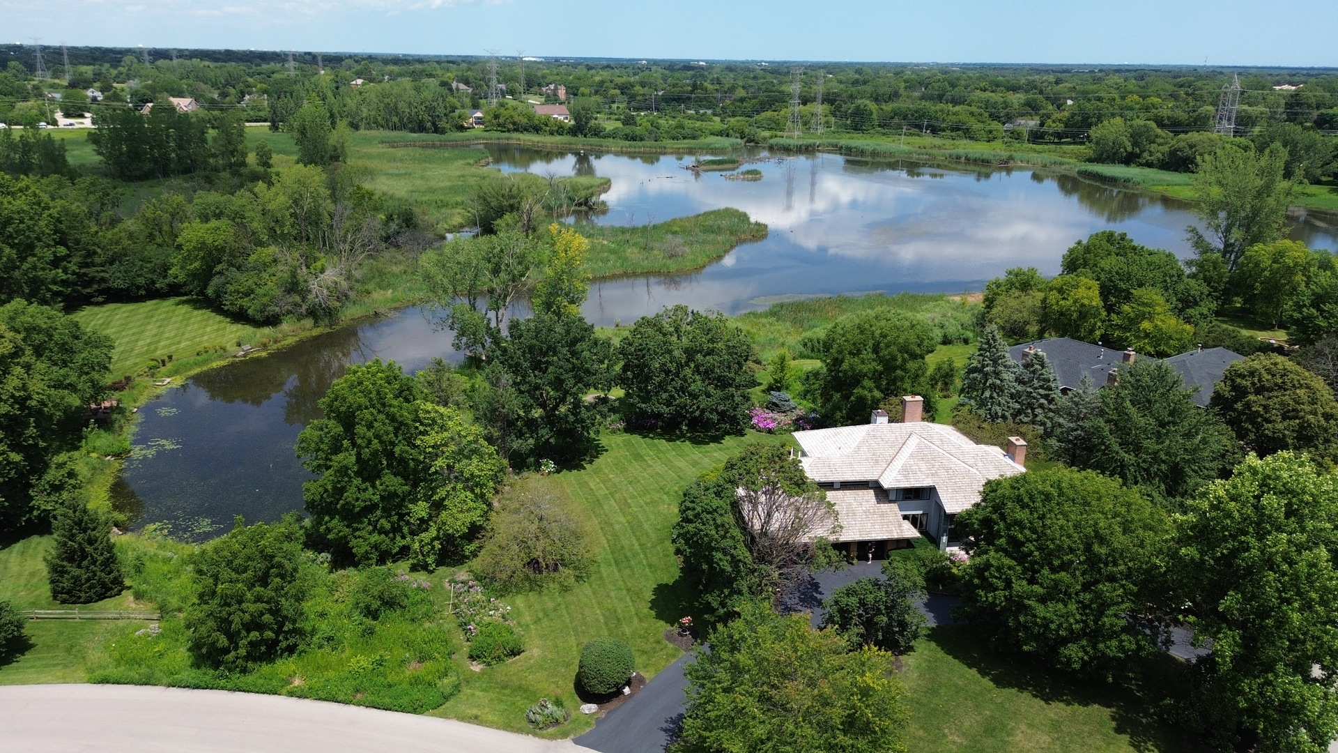 an aerial view of green landscape with trees houses and lake view