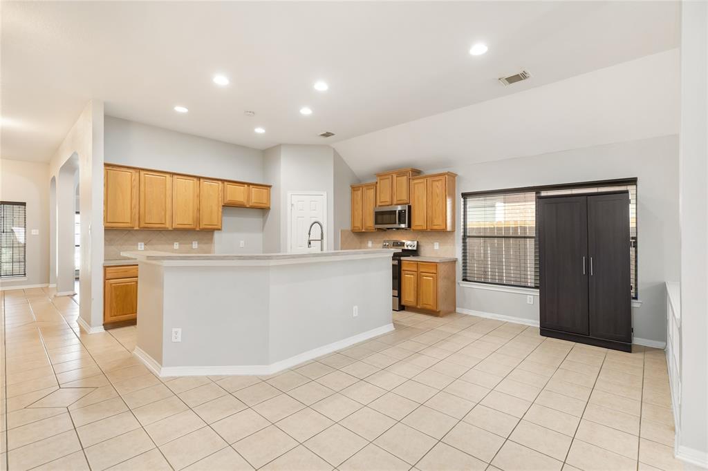 a large kitchen with stainless steel appliances a refrigerator and a stove top oven