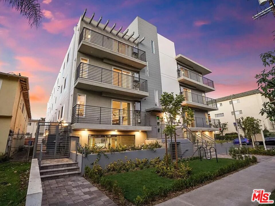 a front view of a residential apartment building with a yard