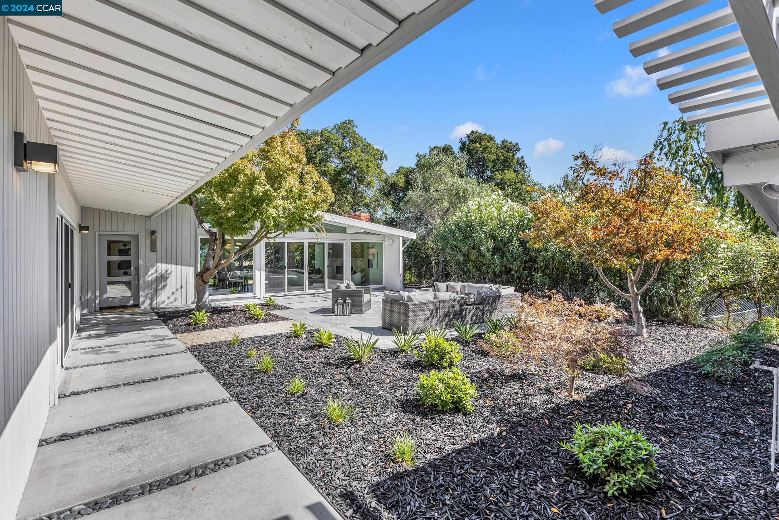 a view of a house with backyard sitting area and garden