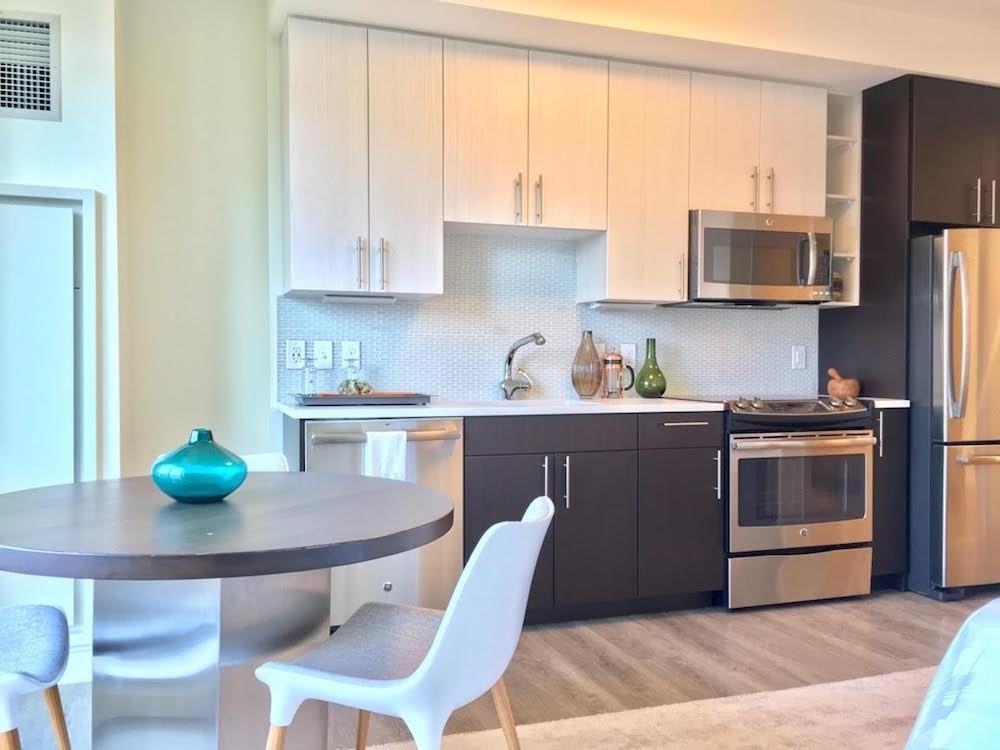 a kitchen with stainless steel appliances a dining table chairs and granite counter tops