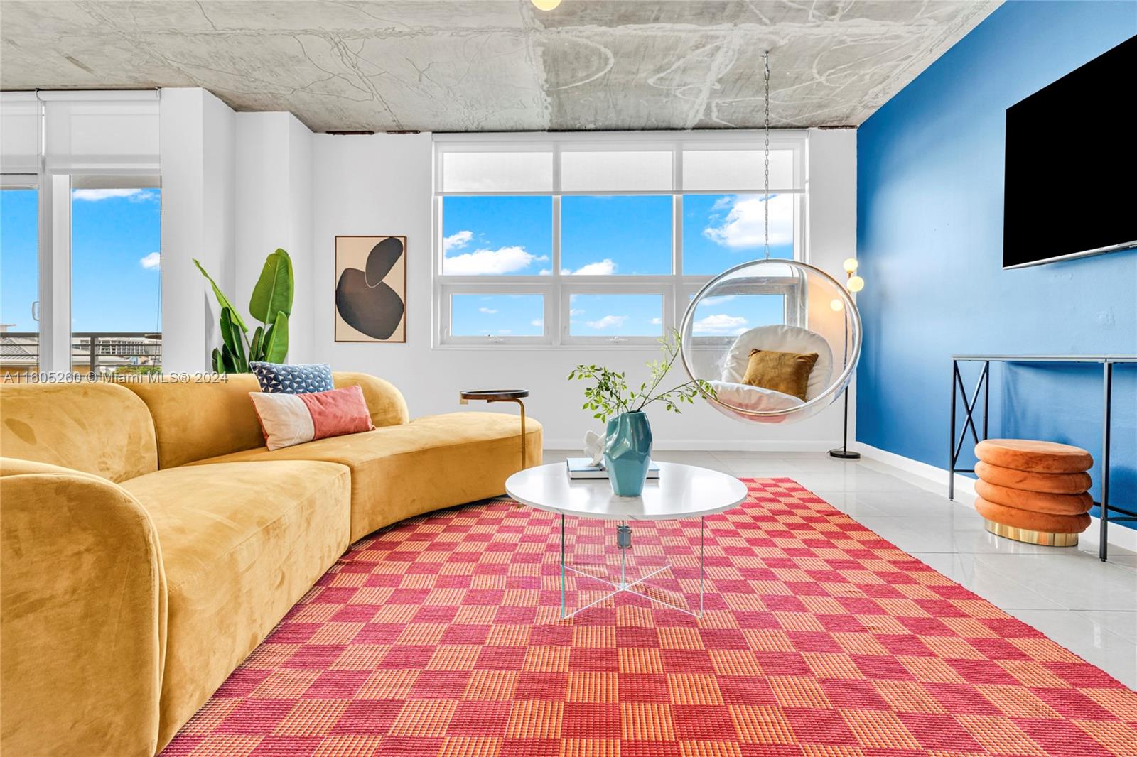 a living room with furniture a flat screen tv and a large window