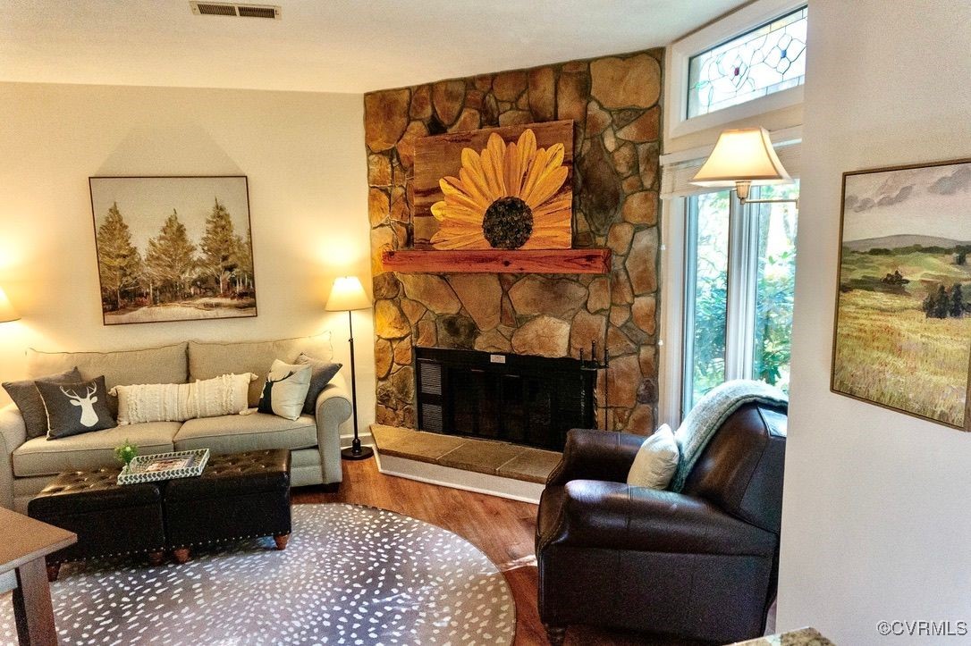 a living room with furniture a fireplace and a large window