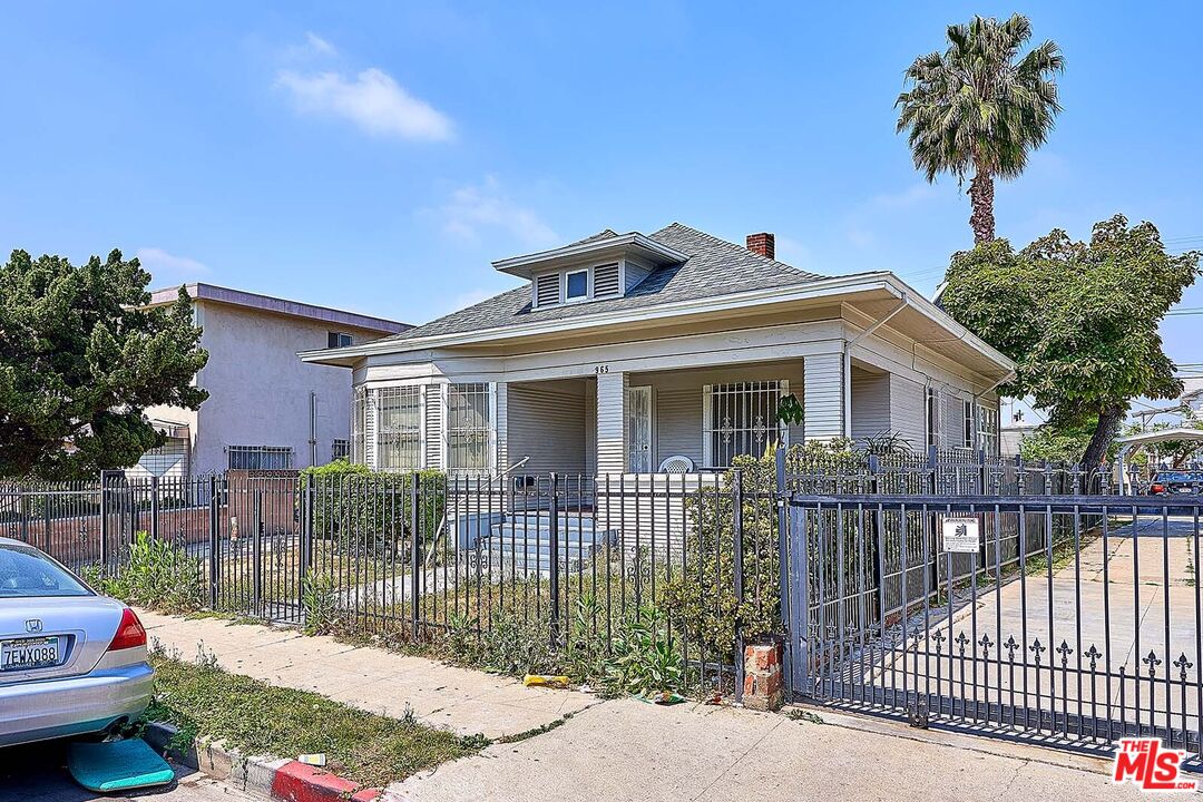 a front view of a house with a garden and plants