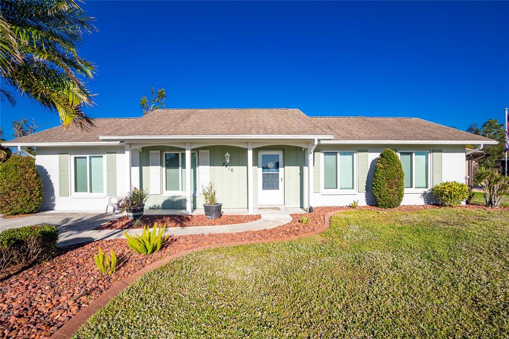 a front view of a house with swimming pool and porch