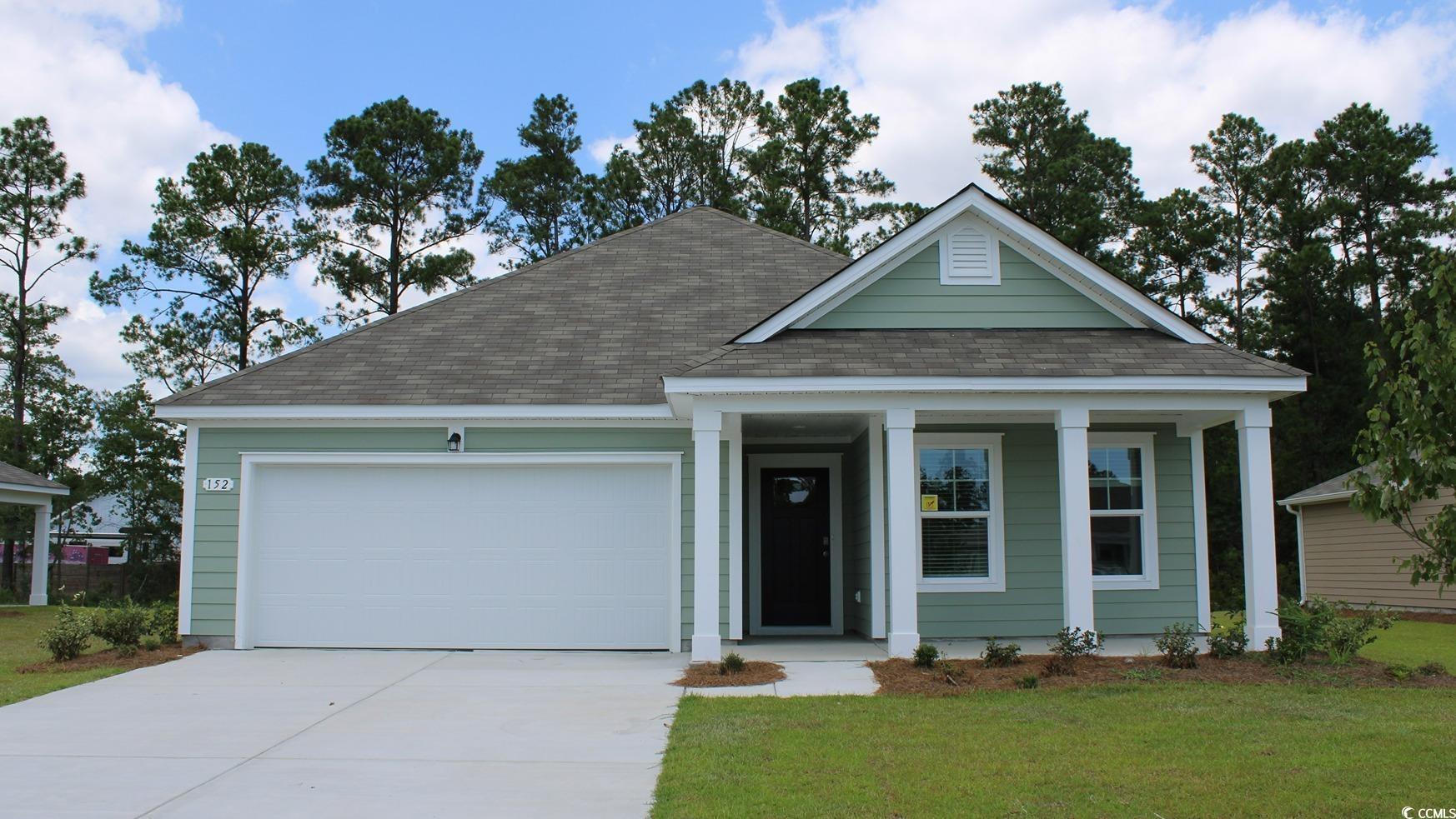 View of front facade with a front yard and a garag