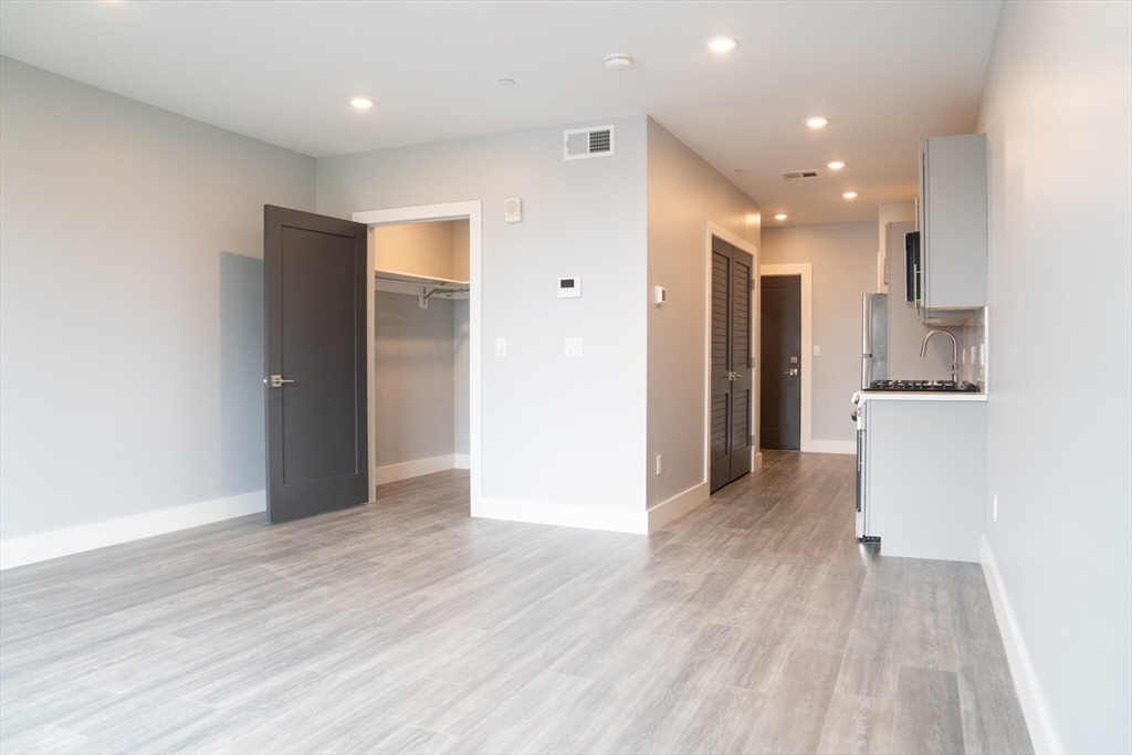 a view of a kitchen with wooden floor and a refrigerator