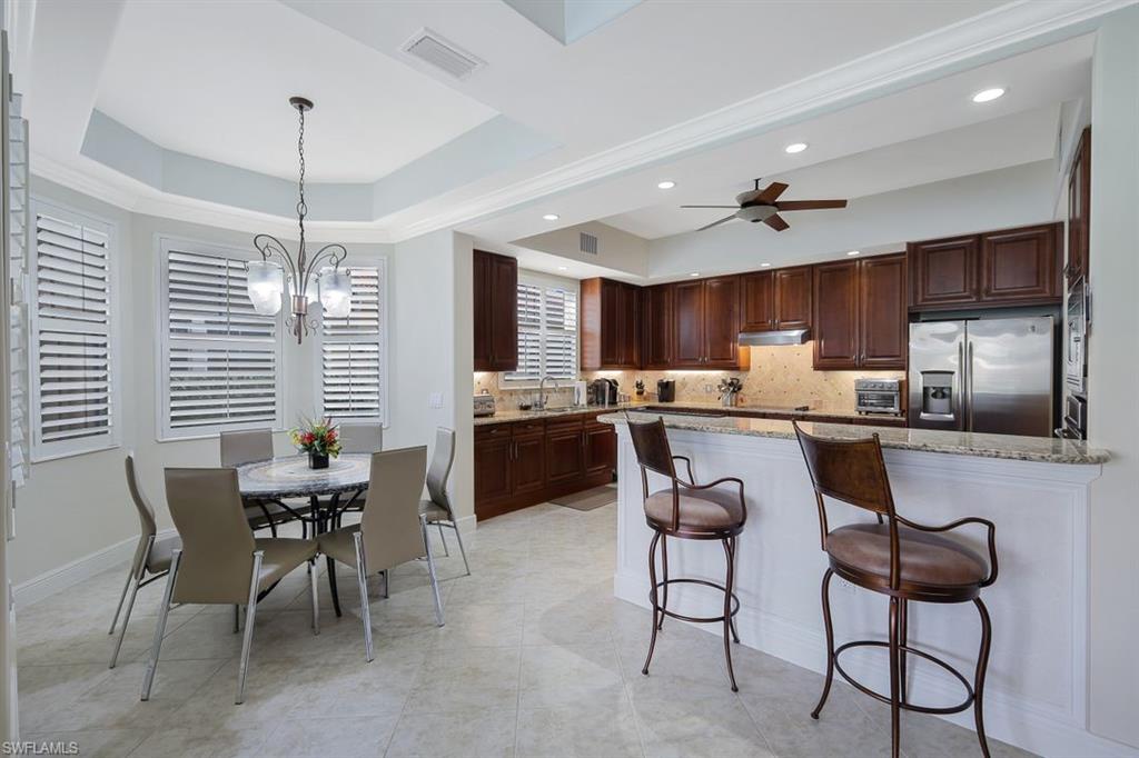 a kitchen with refrigerator a sink and chairs