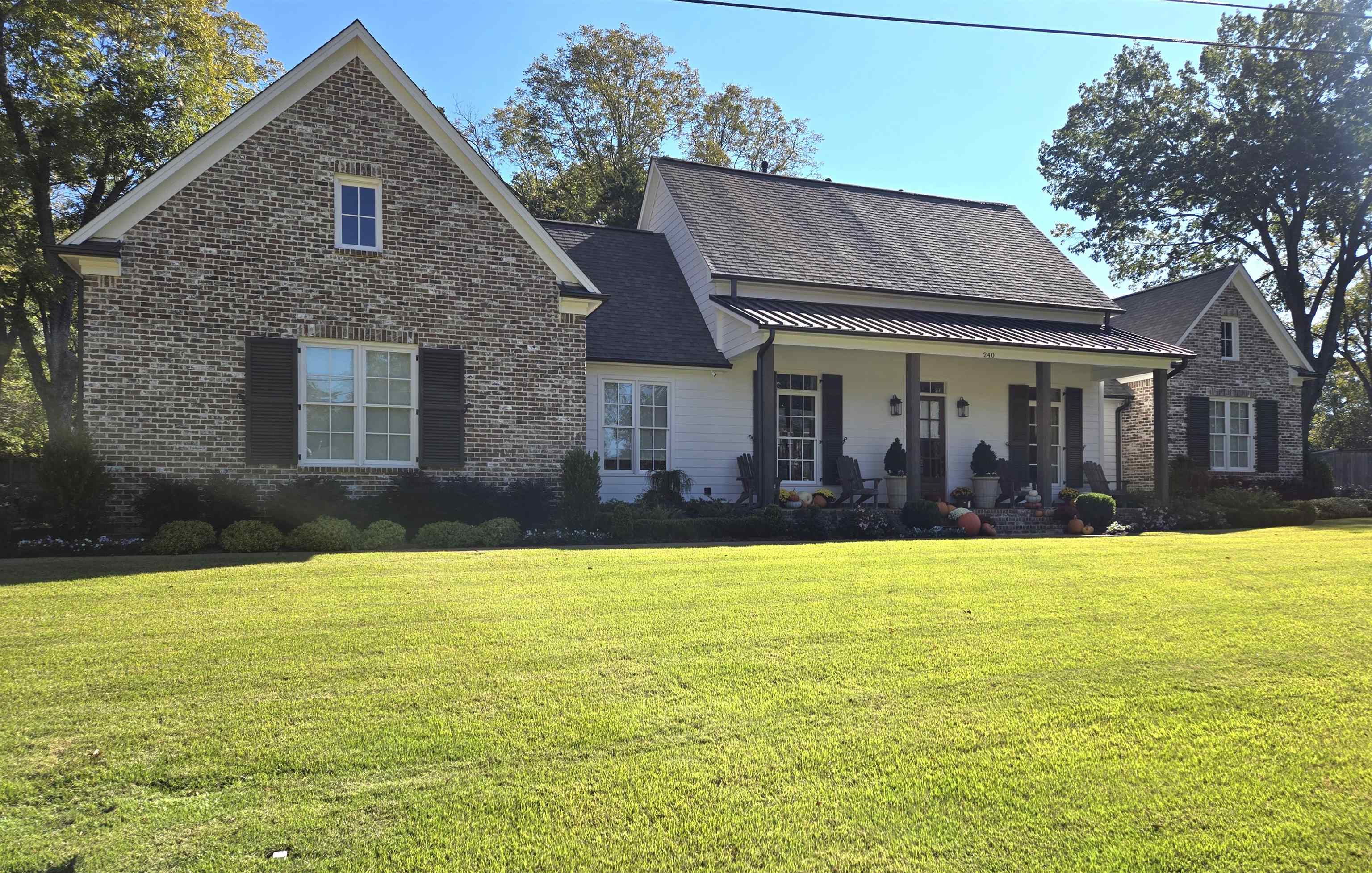 a front view of house with yard and trees in the background