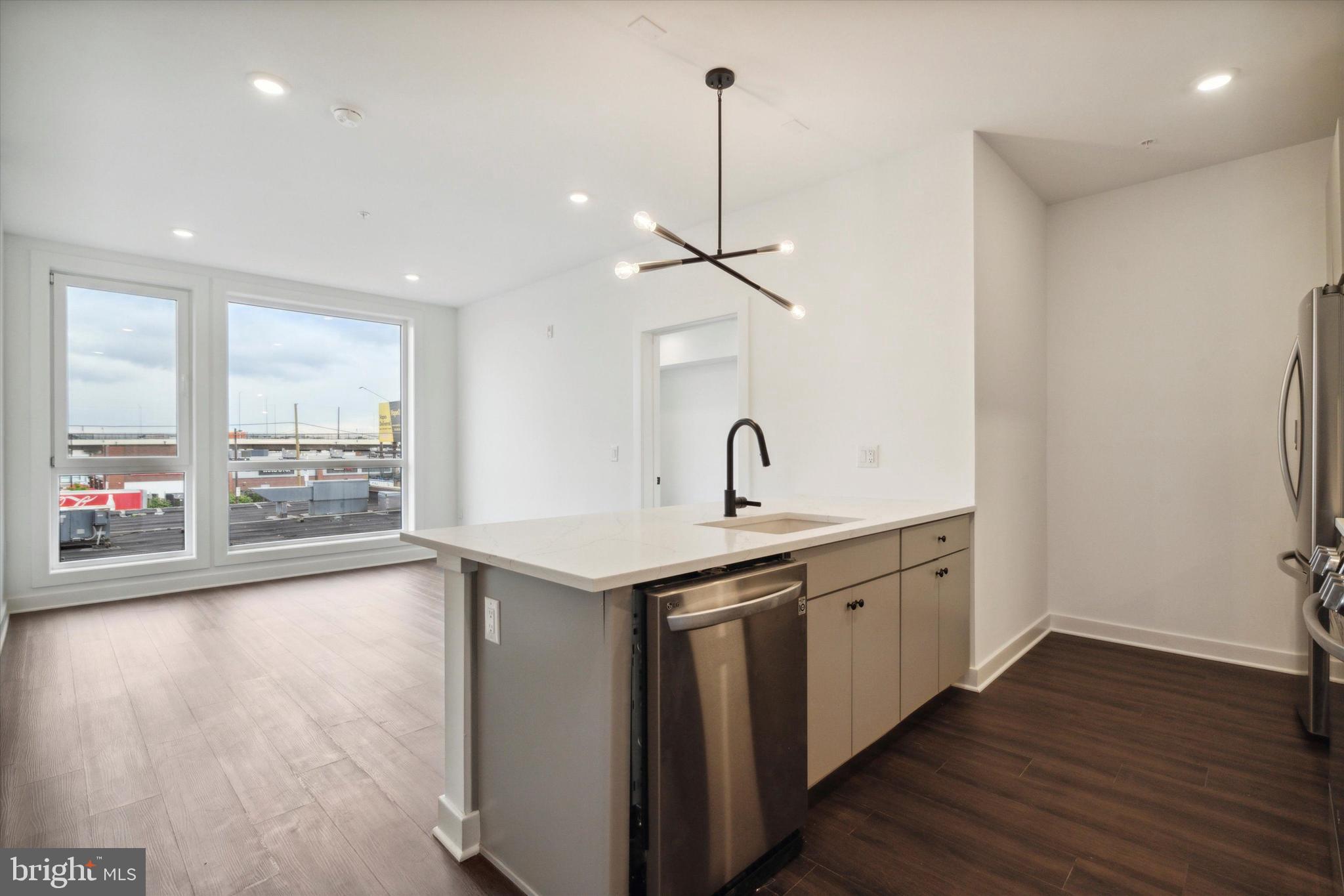 a view of a kitchen with a sink wooden floor and a window