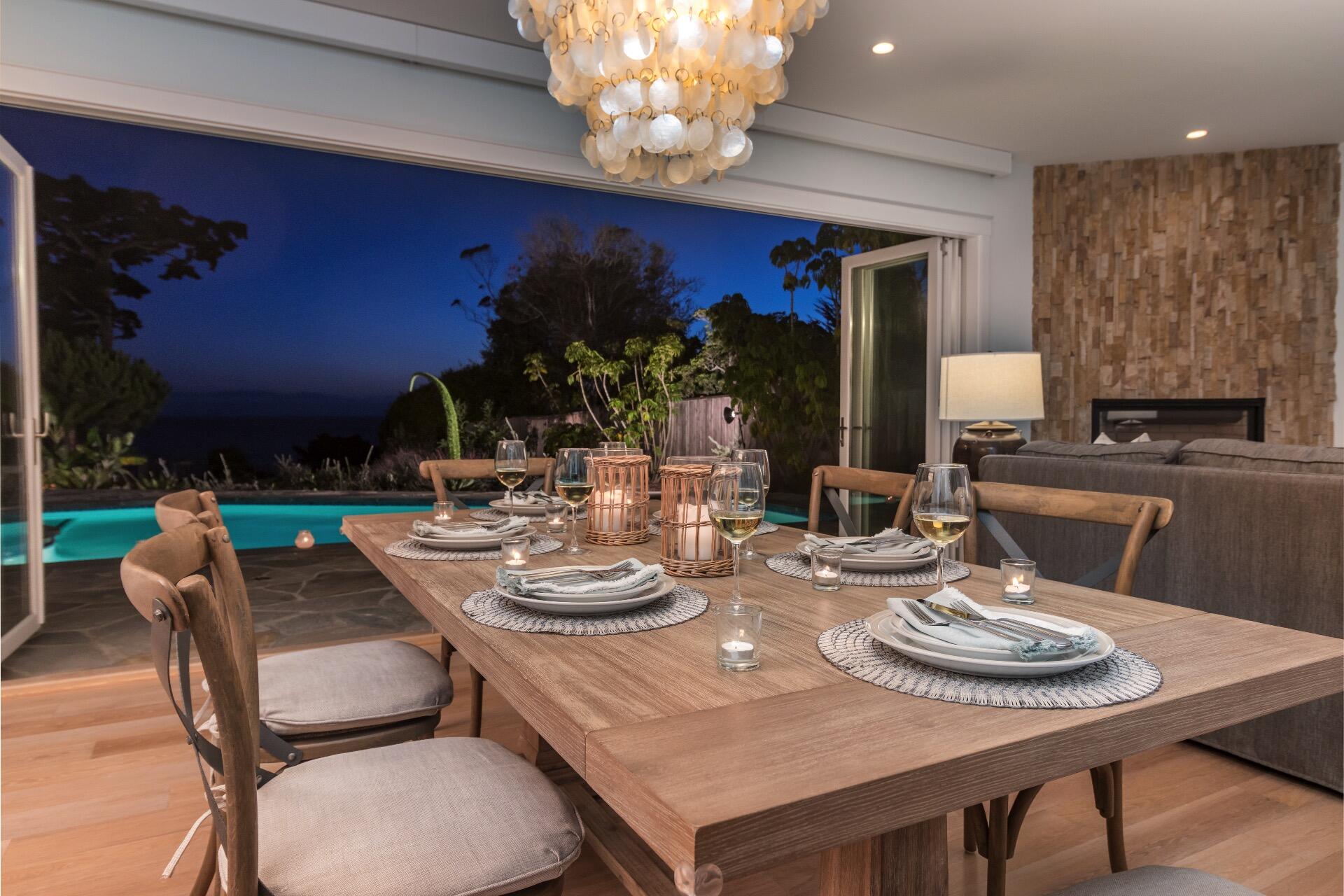 a dining room with furniture a chandelier and kitchen view