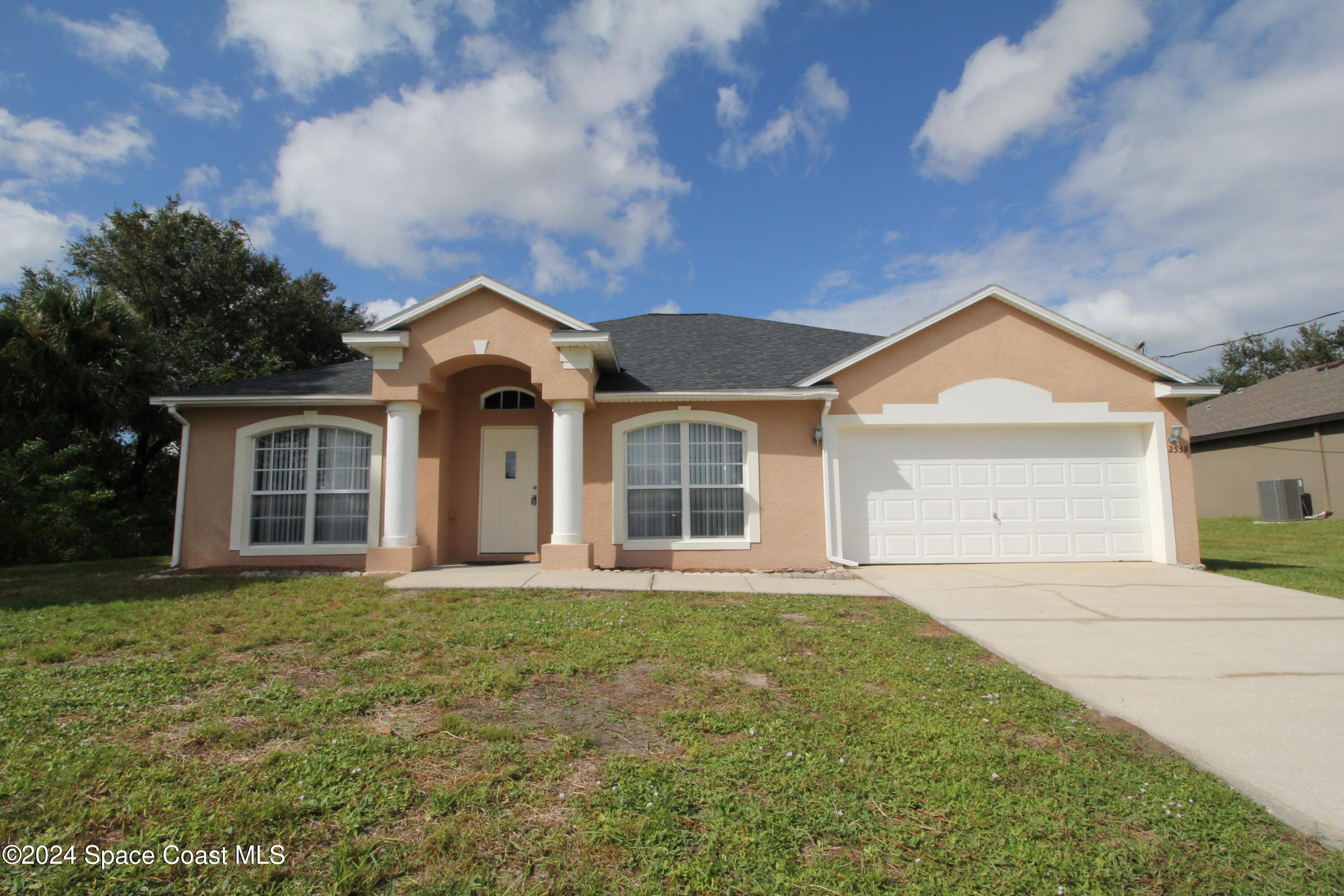 a front view of a house with a yard and garage