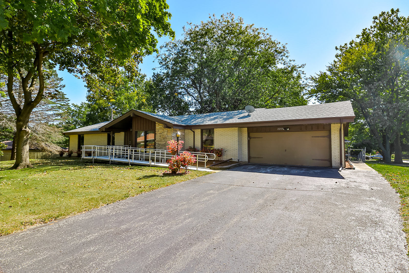 a front view of a house with a yard and trees