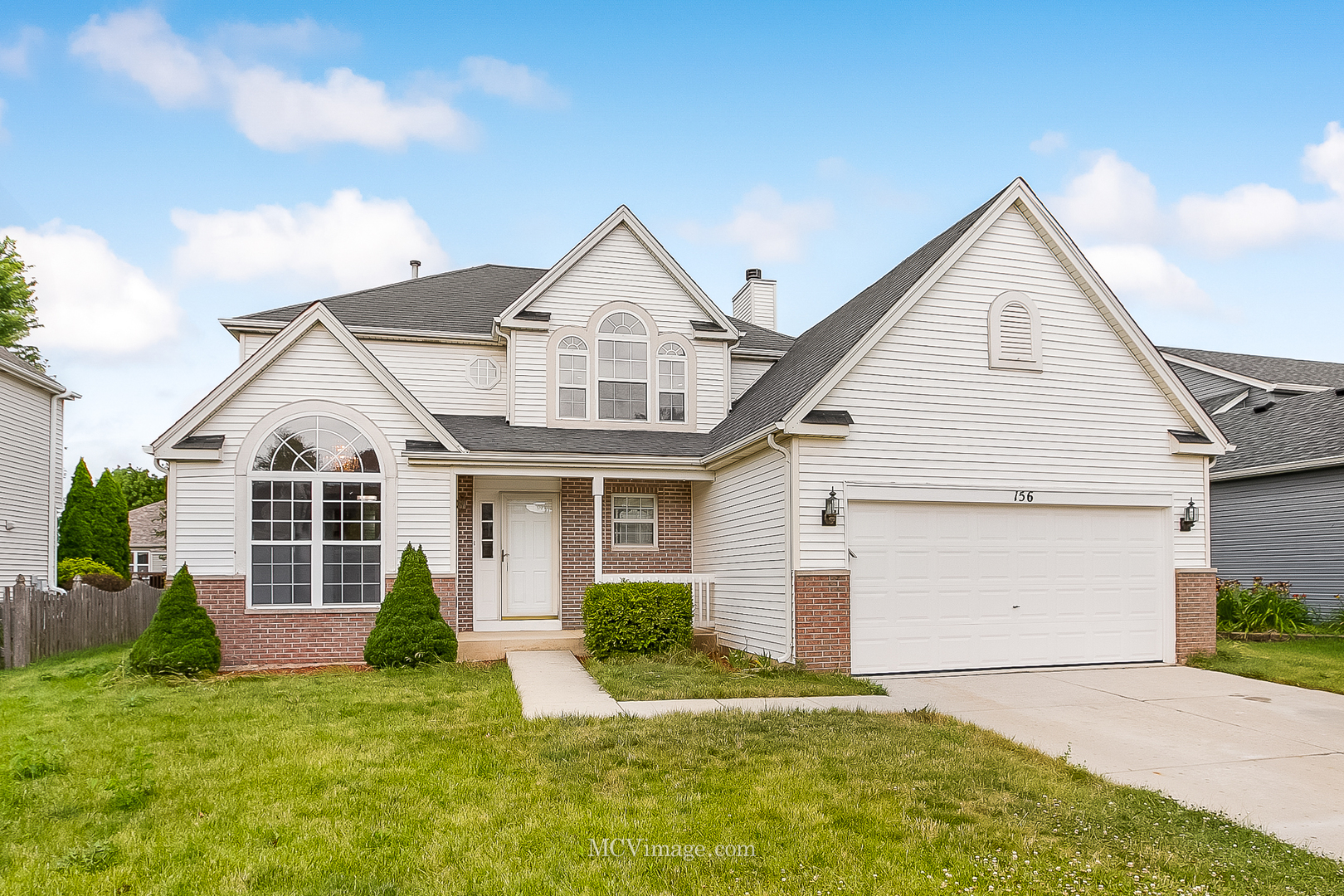 a front view of a house with a yard and garage